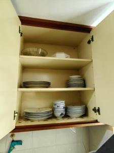 un armario con platos y platos. en AaronL Homestay, en Kota Kinabalu