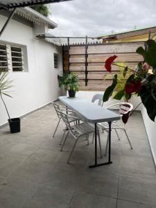 uma mesa e cadeiras num pátio com plantas em Chez Mina em Saint-Louis