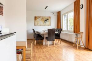 a dining room with a table and black chairs at Villa Sorpe in Winterberg