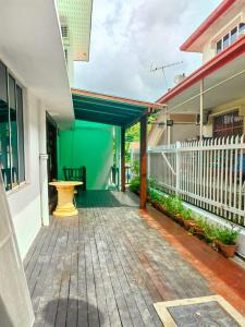 une terrasse couverte d'une maison avec une clôture blanche dans l'établissement AaronL Homestay, à Kota Kinabalu