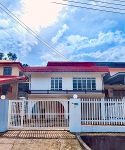 una casa con una valla blanca y una puerta blanca en AaronL Homestay en Kota Kinabalu