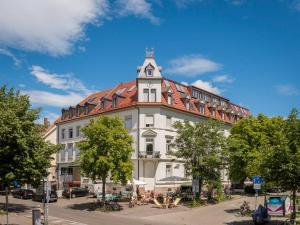 ein großes weißes Gebäude mit einem roten Dach in der Unterkunft Moderne Apartments in attraktivem Altbau in Freiburg im Breisgau