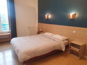 um quarto com uma cama e duas luzes na parede em Auberge du Couesnon em Vendel