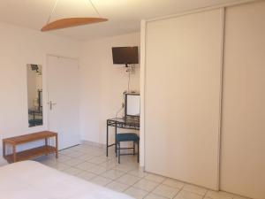 a bedroom with a bed and a desk and a television at Auberge du Couesnon in Vendel