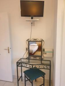 a table with a mirror and a tv on a wall at Auberge du Couesnon in Vendel