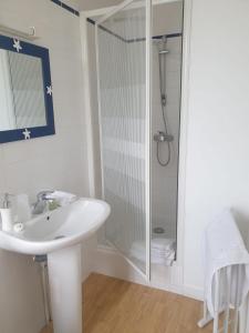uma casa de banho branca com um chuveiro e um lavatório. em Auberge du Couesnon em Vendel
