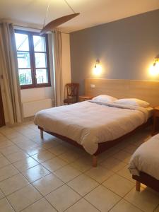 um quarto com uma cama grande e uma janela em Auberge du Couesnon em Vendel