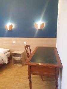 um quarto com uma mesa e duas luzes na parede em Auberge du Couesnon em Vendel