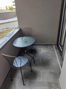 een kleine tafel en 2 stoelen op een balkon bij Joy City Stay Armoniei 01 in Timişoara