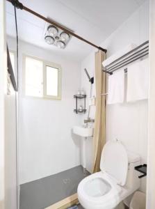 uma casa de banho branca com um WC e um chuveiro em Shanghai Hills&Well-time Scandi Loft em Xangai