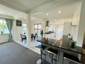 a kitchen and living room with a table and chairs at Charming & Modern 4 BR in Lower Hutt