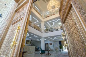 a hallway in a building with a chandelier at Poykent Naqshband in Bukhara
