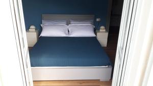 - une chambre avec un lit aux murs bleus dans l'établissement Casa Aurelia, Pognana Lario, à Pognana Lario