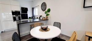 een keuken en eetkamer met een witte tafel en stoelen bij Black&White Home-by So'SerenityHome-Balcon-Parking in Cluses