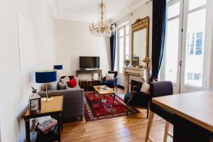ein Wohnzimmer mit einem Sofa und einem Tisch in der Unterkunft Bordeaux Saint André - elegant, central and quiet in Bordeaux