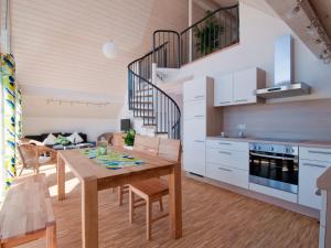 uma cozinha e sala de jantar com uma mesa de madeira e cadeiras em Winzercafe Neipperg Ferienwohnungen em Brackenheim
