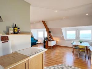 uma cozinha e sala de estar com mesa e cadeiras em Fenêtres sur mer em Cayeux-sur-Mer