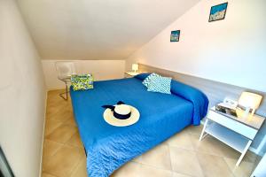 ein Schlafzimmer mit einem blauen Bett mit Hut darauf in der Unterkunft Rooftop flat in Amalfi in Amalfi