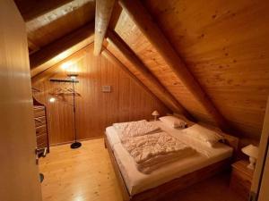 1 dormitorio con 1 cama en un ático de madera en Ferienhaus "Bella Vista" in Lottigna mit grossem Umschwung, Pergola, Grill und Pizzaofen en Lottigna