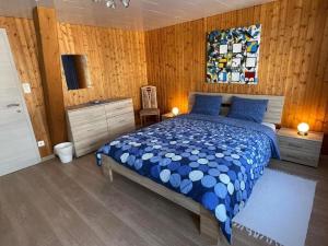Ferienwohnung Hälmli في هايدن: غرفة نوم بسرير وجدار خشبي