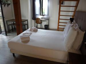um quarto com uma grande cama branca com toalhas em Apparts' hôtel Casa di a Restonica em Corte