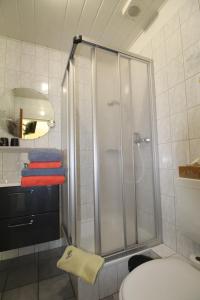 La salle de bains est pourvue d'une douche, de toilettes et de serviettes. dans l'établissement Pension Sandra, à Neuharlingersiel