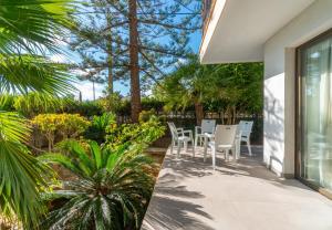 eine Terrasse mit Stühlen und Pflanzen an einem Haus in der Unterkunft Apartamento Ponent 4 in Cala Ratjada