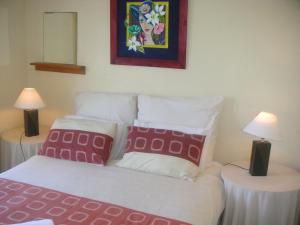 1 dormitorio con 1 cama y 2 mesas con lámparas en Waterside Living CL07, en Jeffreys Bay