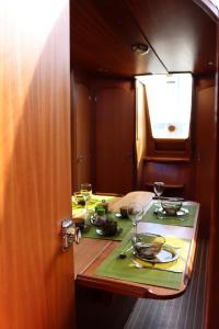 a table with glasses and plates on it on a boat at Jachty Nubian 29 (Pływający apartament) in Polańczyk