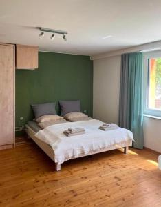 Cama grande en habitación con pared verde en 1,5 Zimmer Ferienwohnung en Lucerna