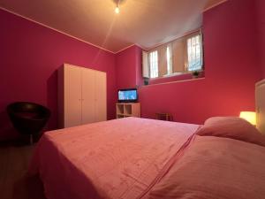 カターニアにあるTavernetta Cortile Dalmaziaのピンクの壁のベッドルーム1室(大型ベッド1台付)