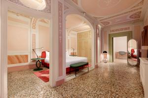 a bedroom with a bed and a room with a mirror at Palazzo Dei Fiori by Room Mate in Venice
