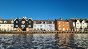 a row of houses next to a body of water at The Artist's Loft in Wivenhoe (Church View) in Wivenhoe