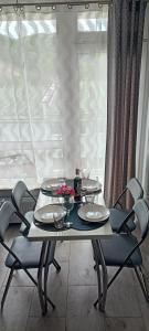 a table with chairs and plates and a window at APARTAMENT USTROŃ 84 in Ustroń