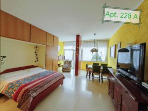 1 dormitorio con 1 cama grande y comedor en Garda Apartments in Euroresidence, en Garda