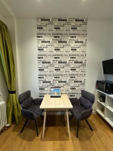 einen Tisch mit Stühlen und einen Laptop an der Wand in der Unterkunft Moderne Apartments in attraktivem Altbau in Freiburg im Breisgau