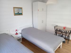 um quarto com 2 camas e uma mesa em APARTMAN “POD KRALJEVICOM” em Zaječar