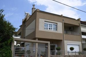 una casa marrone con una recinzione di fronte di Avenue Luxury Apartments a Alexandroupoli