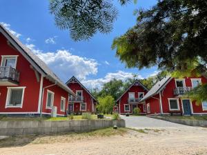 una fila de casas rojas en una calle en Urlaub am Plätlinsee - Haus Odin, en Wustrow
