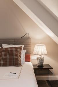 a bedroom with a bed and a table with a lamp at De Lindenhoeve Boutique Hotel in Sluis