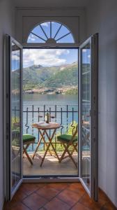 Zimmer mit einem Balkon mit einem Tisch und Aussicht in der Unterkunft Casa Emi in Lezzeno