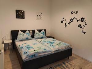 ein Schlafzimmer mit einem Bett mit blauen Blumen darauf in der Unterkunft Pension Hexagon in Spittal an der Drau