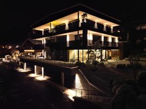 a house lit up at night with lights at Timeless Dolomites Apartments in Dobbiaco
