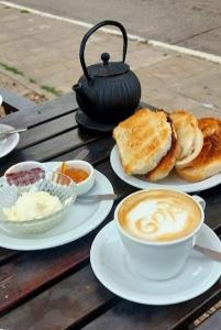 una mesa con platos de comida y tazas de café en Costanera Goya Apart & Hotel en Goya