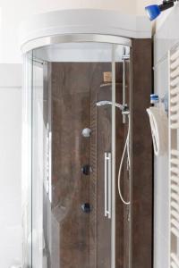 een douche met een glazen deur in de badkamer bij Casa Emi in Lezzeno