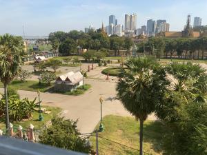 einen Park mit Palmen und eine Stadt im Hintergrund in der Unterkunft Julieka’s Guesthouse in Phnom Penh