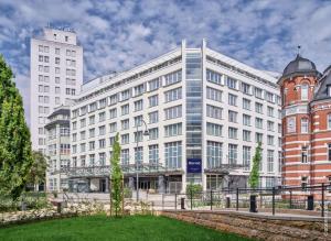 un gran edificio blanco con una torre de reloj delante en Dorint Hotel Esplanade Jena, en Jena