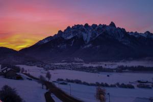 a view of a town in the snow with mountains at Timeless Dolomites Apartments in Dobbiaco