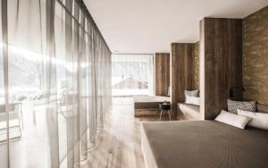 a living room with a large window and a couch at Timeless Dolomites Apartments in Dobbiaco