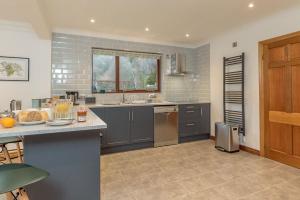 a kitchen with gray cabinets and a counter top at Creigia-Betws in Betws-y-coed